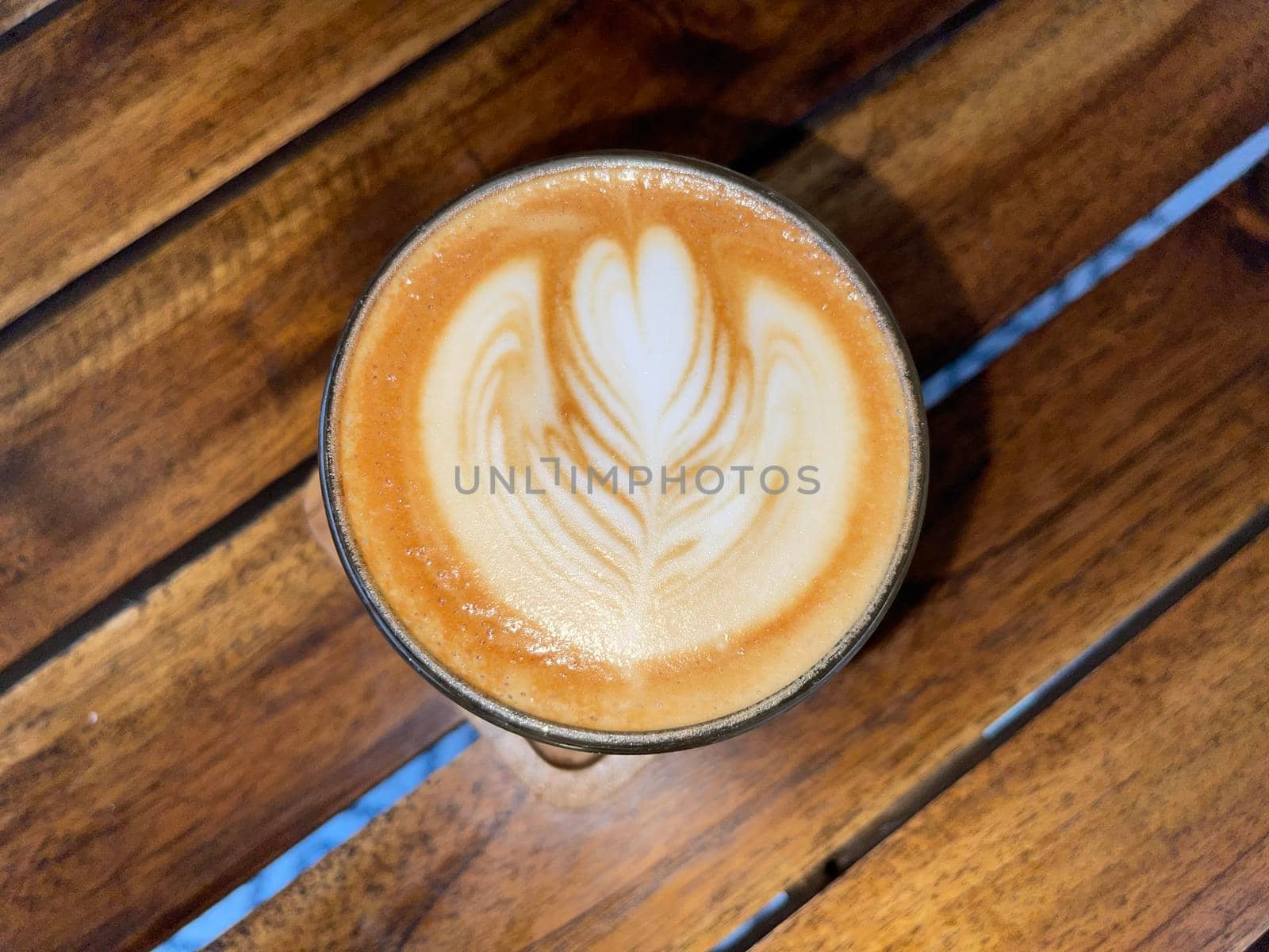 beautiful cup of cappuccino coffee with latte art in the wooden space background