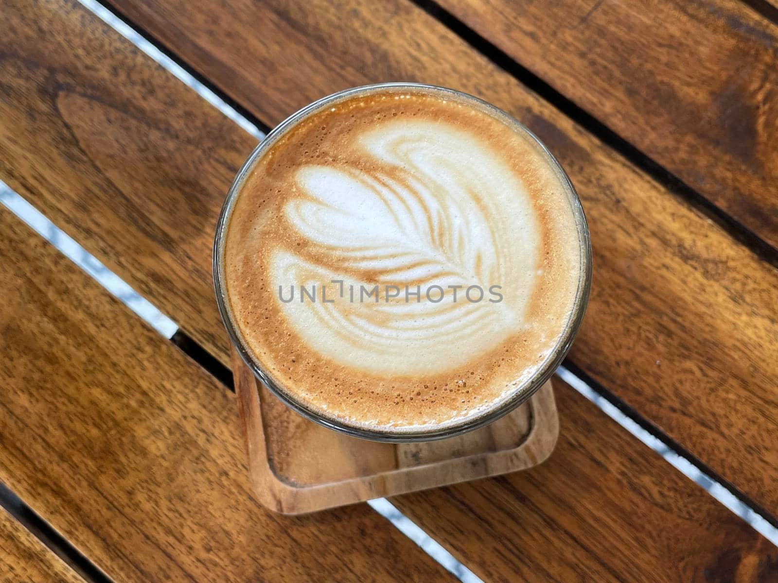 beautiful cup of cappuccino coffee with latte art in the wooden space background