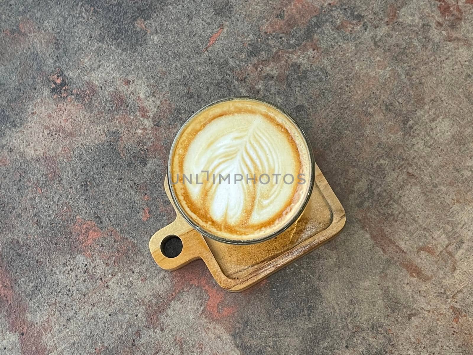 beautiful cup of cappuccino coffee with latte art in the wooden space background