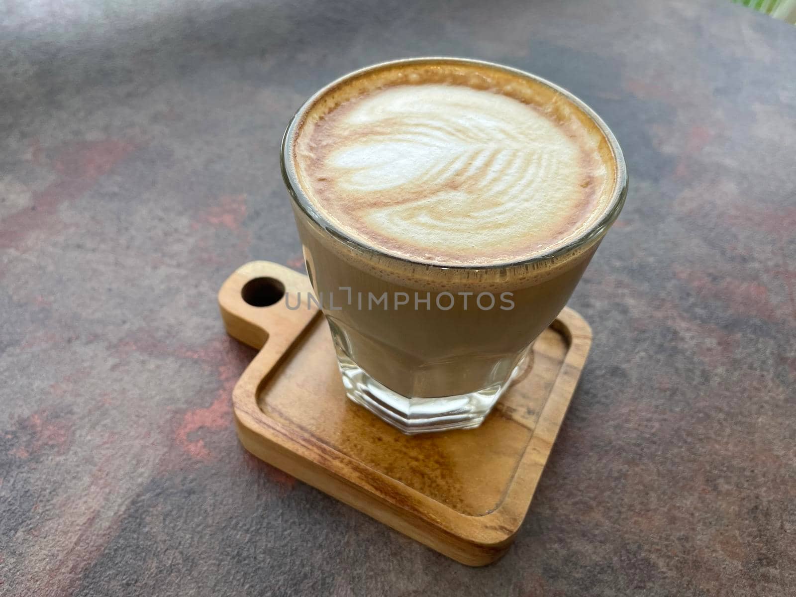 beautiful cup of cappuccino coffee with latte art in the wooden space background