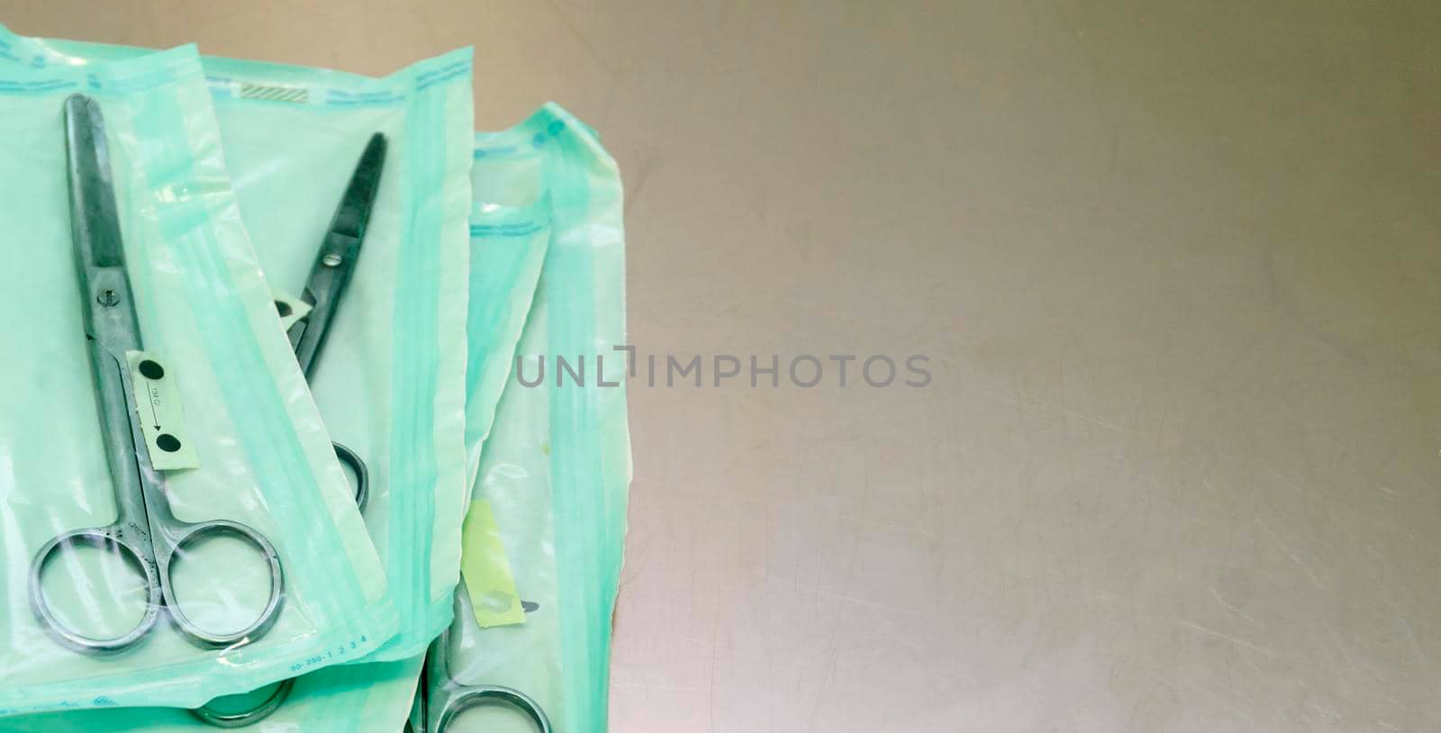 medical scissors on a table with a shallow depth of field in sterile bags.