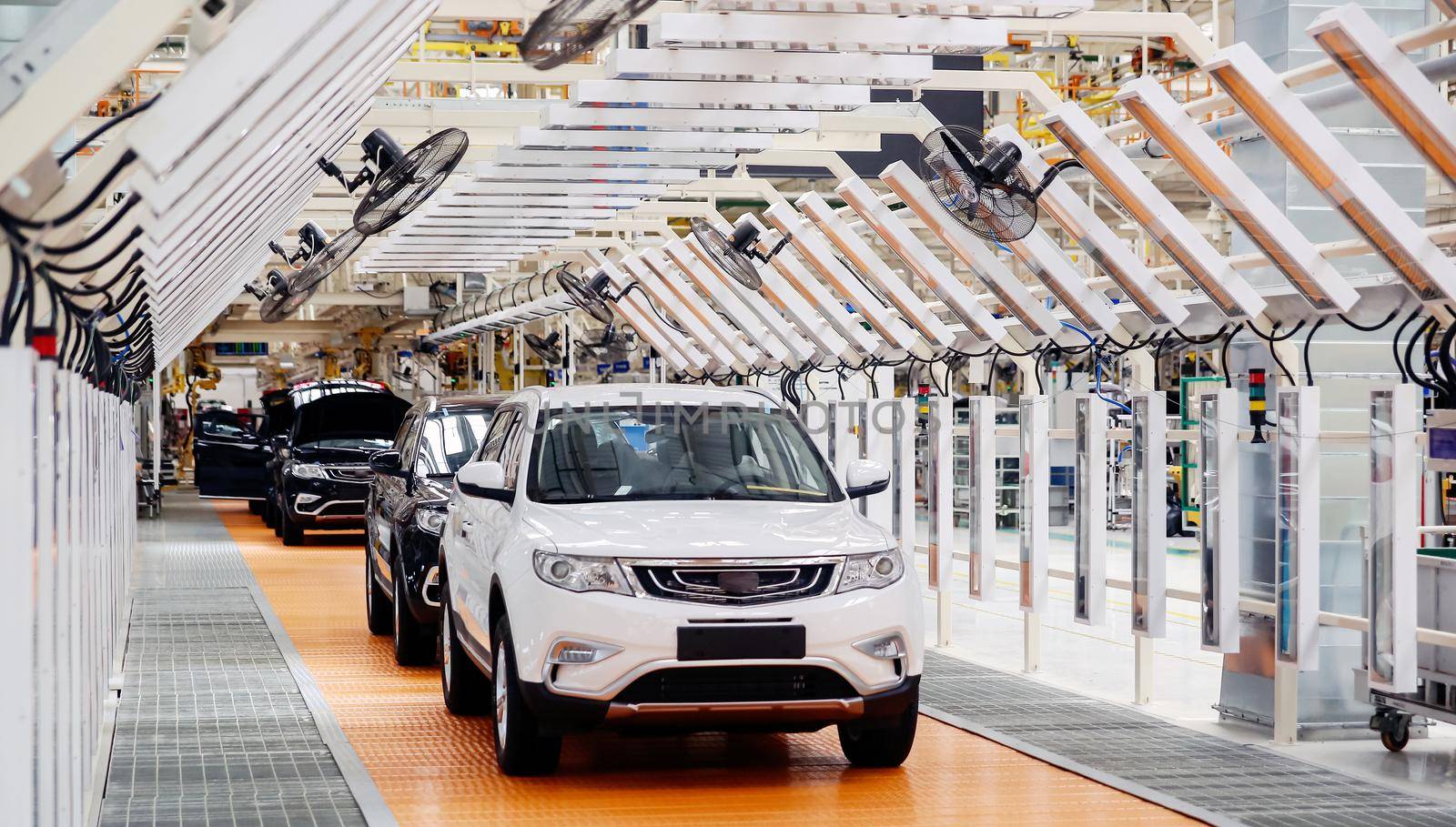 Factory for the production of cars, factory conveyor. Cars are being assembled.