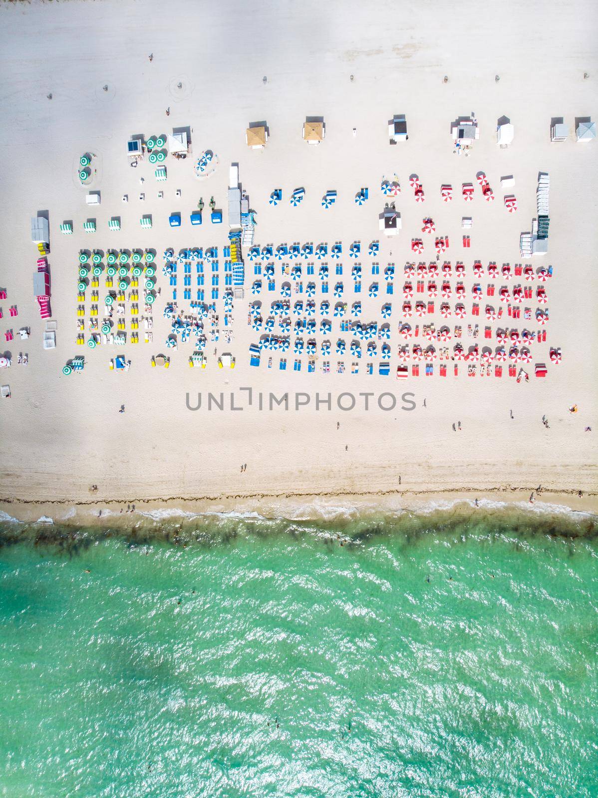 Drone aerial view at Miami South Beach Florida, Beach with colorful chairs and umbrellas by fokkebok