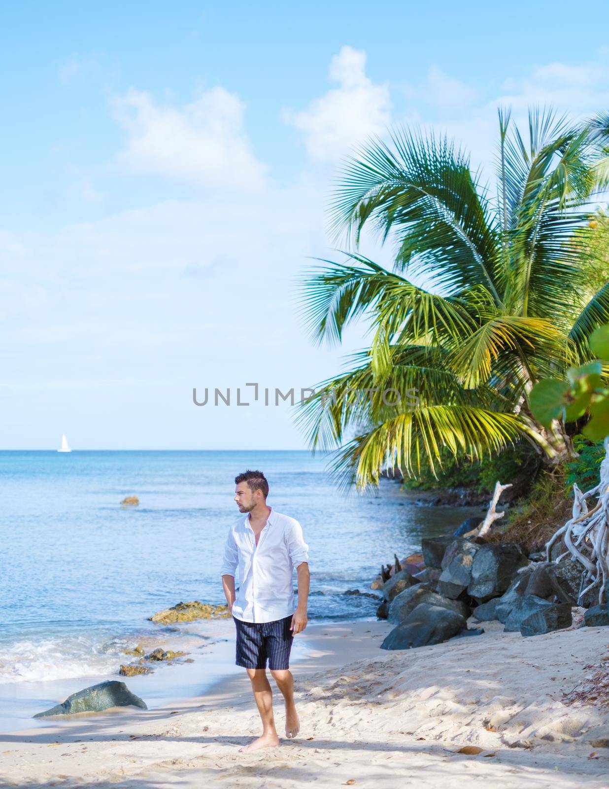 young men in a swim short on vacation in Saint Lucia, luxury holiday Saint Lucia Caribbean, men and woman on vacation at the tropical Island of Saint Lucia Caribbean. Calabash beach St Lucia Caribbean