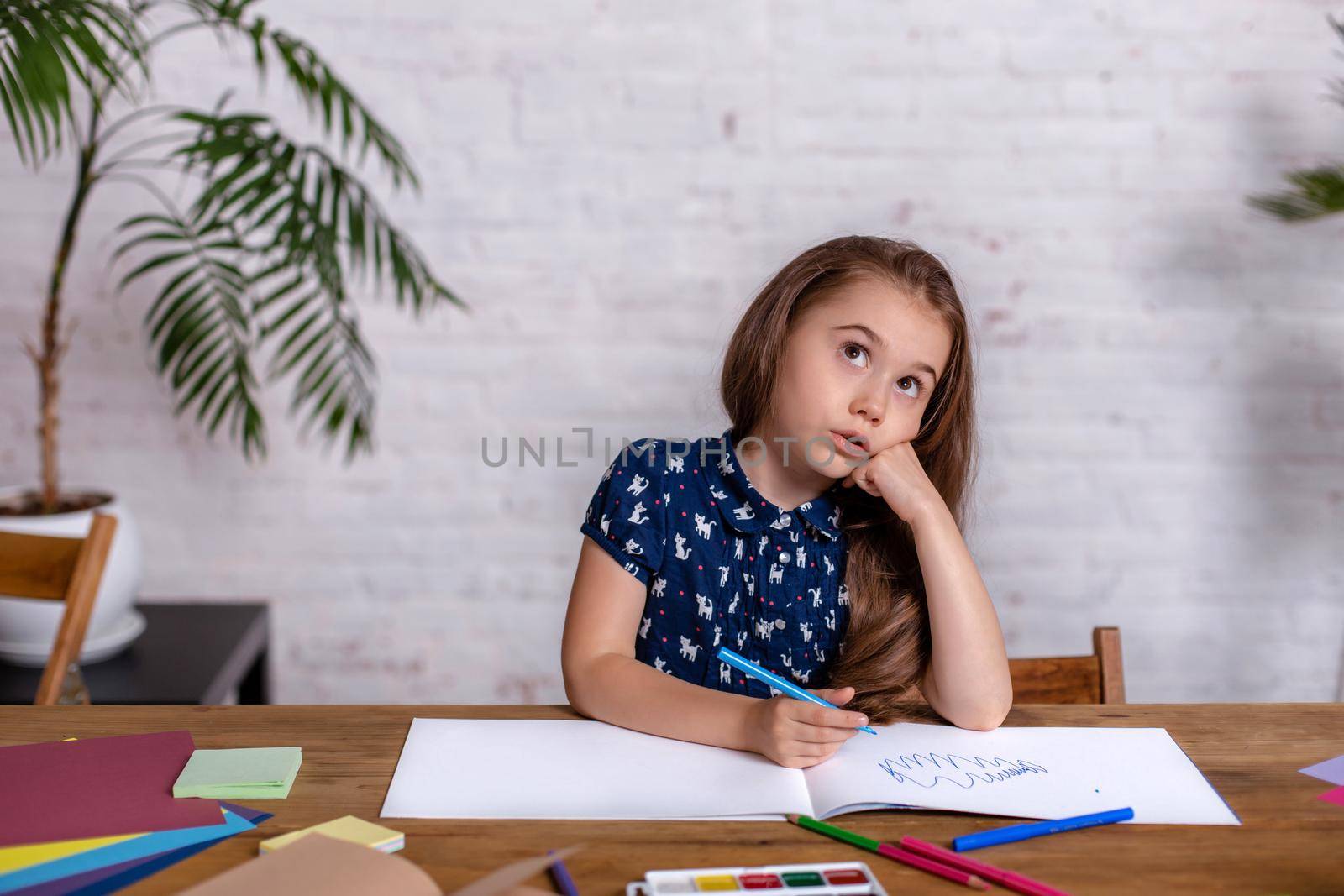 Cute portrait of little kid girl drawing by multi-colored pencils at home. Concept of kids hobby or childhood, happy lifestyle