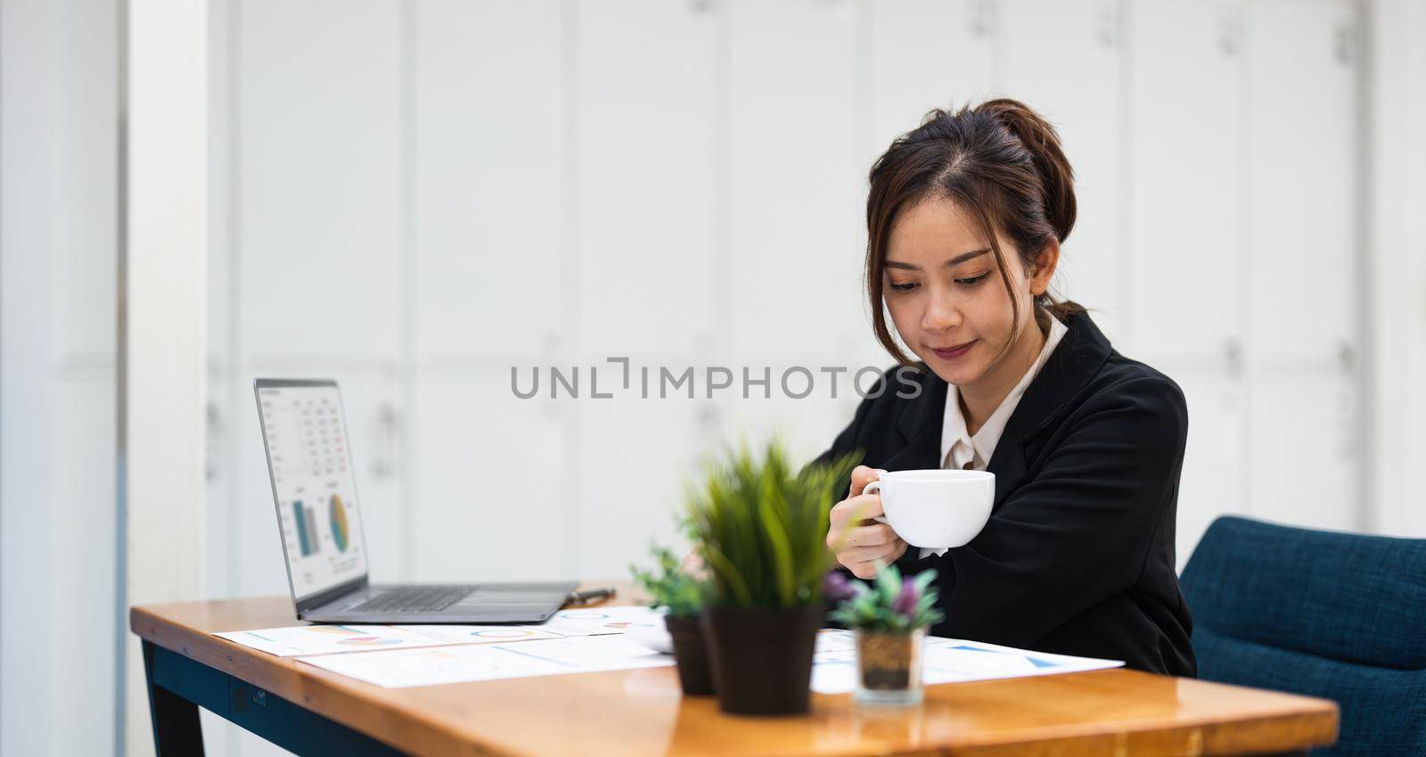 business woman or accountant working on calculator to calculate business data, accountancy document and laptop computer at office, business concept.