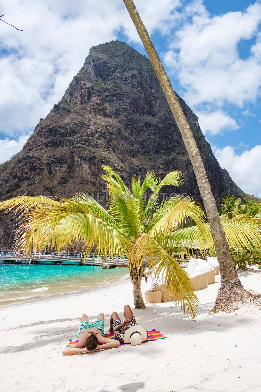 couple sunbathing on the beach during summer vacation on a sunny day, men and woman on vacation at the tropical Island of Saint Lucia Caribbean. Sugar beach St Lucia Caribbean