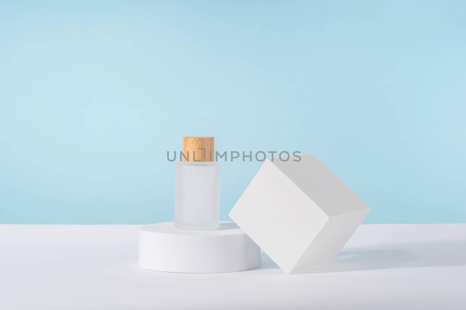 Cosmetic luxury cream tube bottle mockup on blue background on pedestal podium. Unbranded lotion beauty product packaging. Product presentation mock up. by photolime