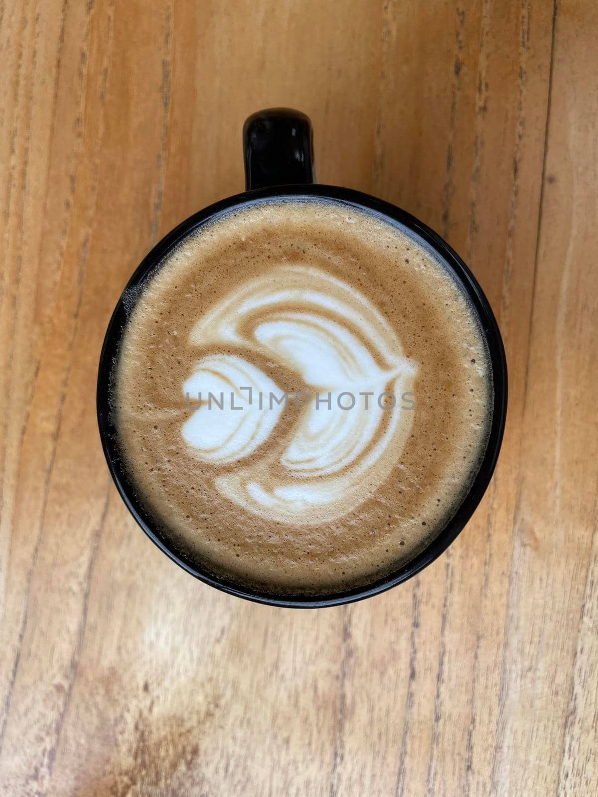 beautiful cup of cappuccino coffee with latte art in the wooden space background