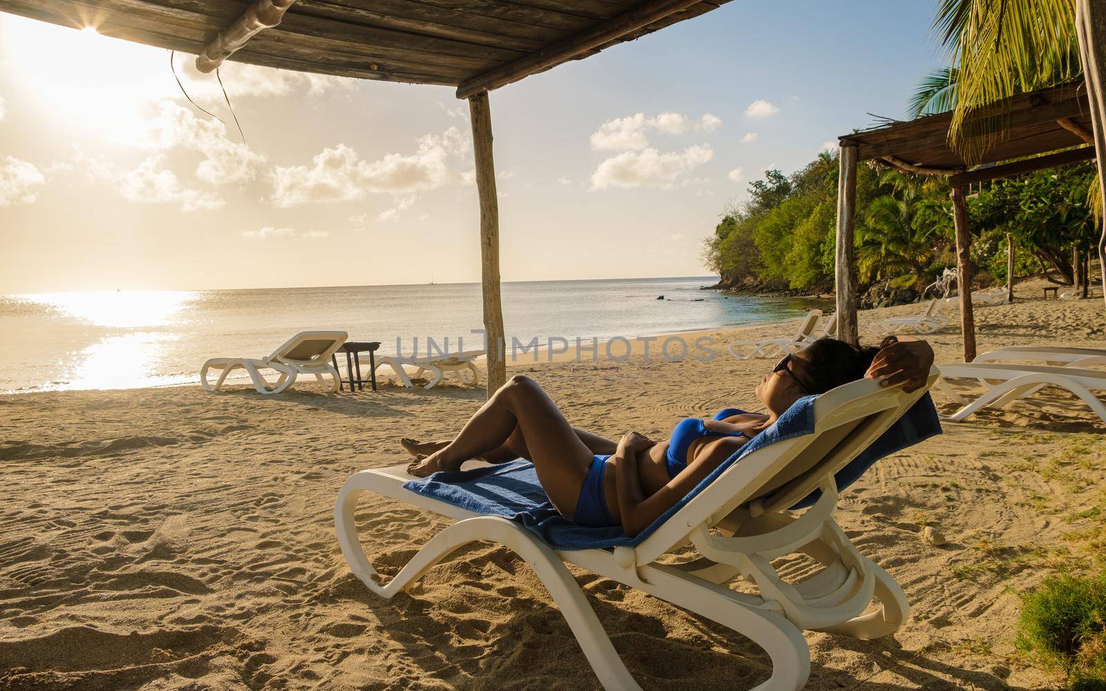 Asian women relaxing on a beach chair during sunset at Saint Lucia Caribbean, Asian women tanning on the beach
