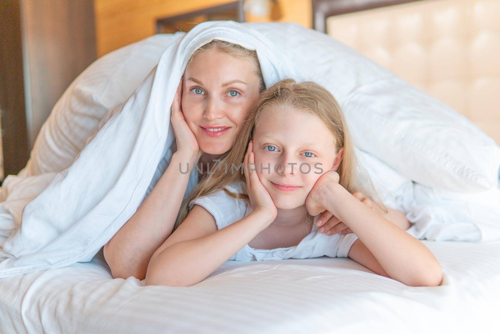 Blanket family over woman glad daughter bed head girl eyes, from view morning for pillow from person happy, nap comfortable. Room face one, day