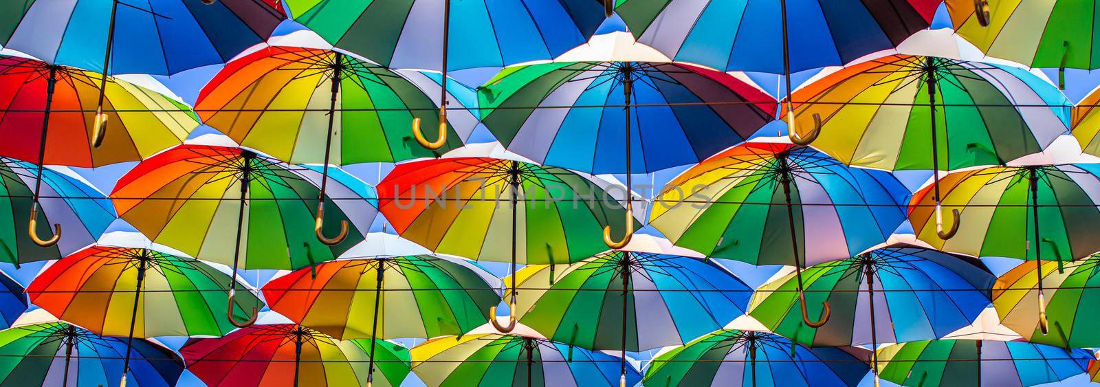 Colorful umbrellas Blue, green, red, rainbow umbrellas background Street with umbrellasin the sky Street decoration. by vikiriki