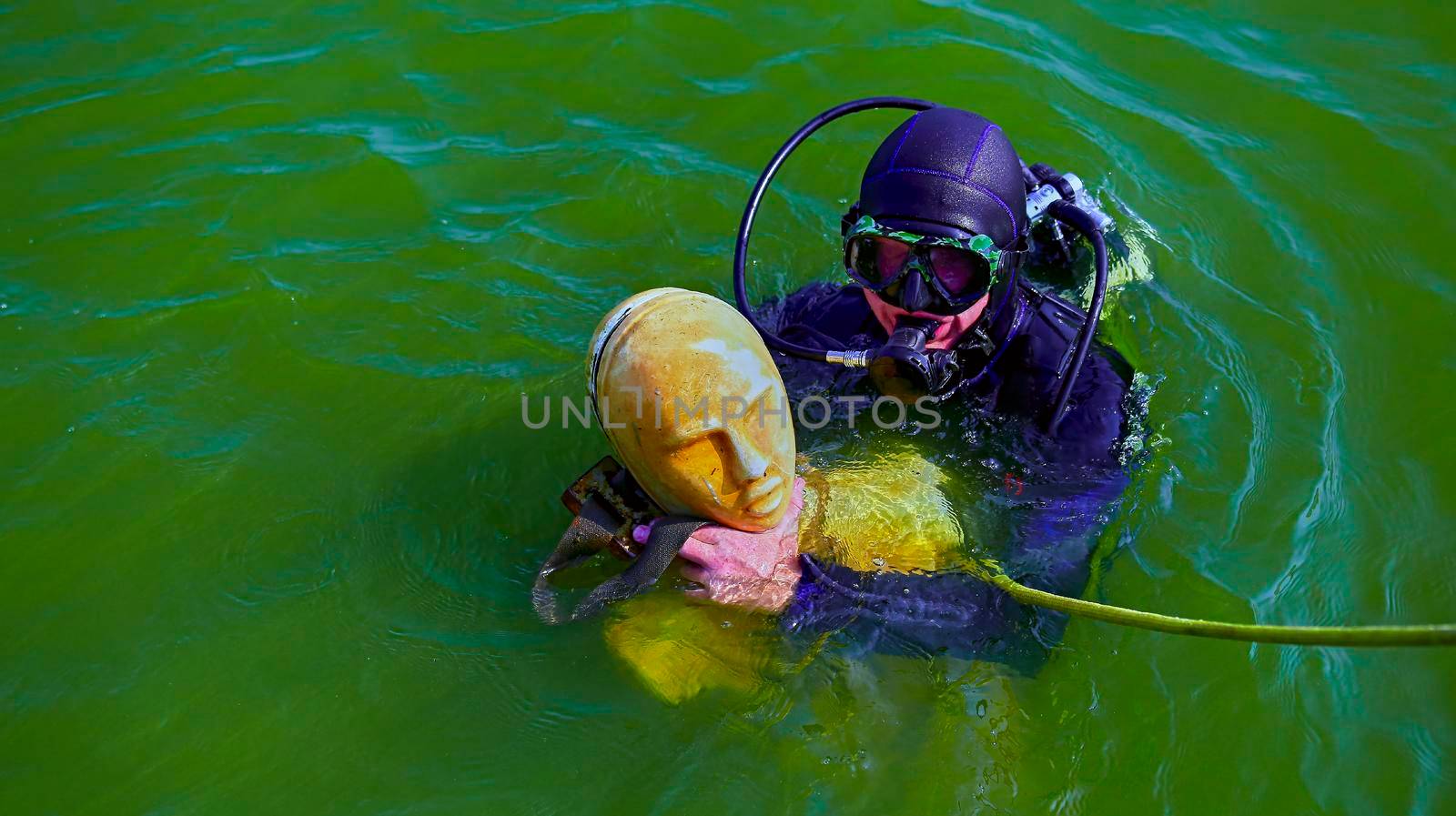 scuba diving training for lifeguards. detection of people. lifeguard is training with a dummy.
