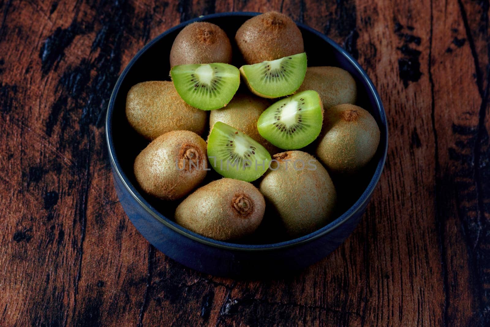 kiwi in a blue ceramic dish on an old wooden table