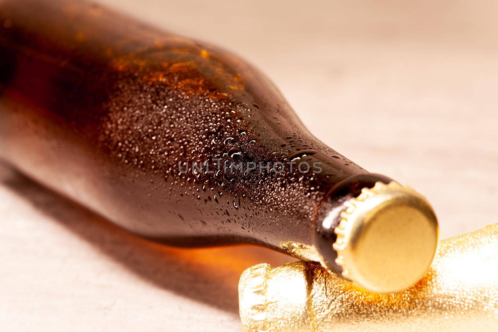 a bottle of beer amber lying with its capsule