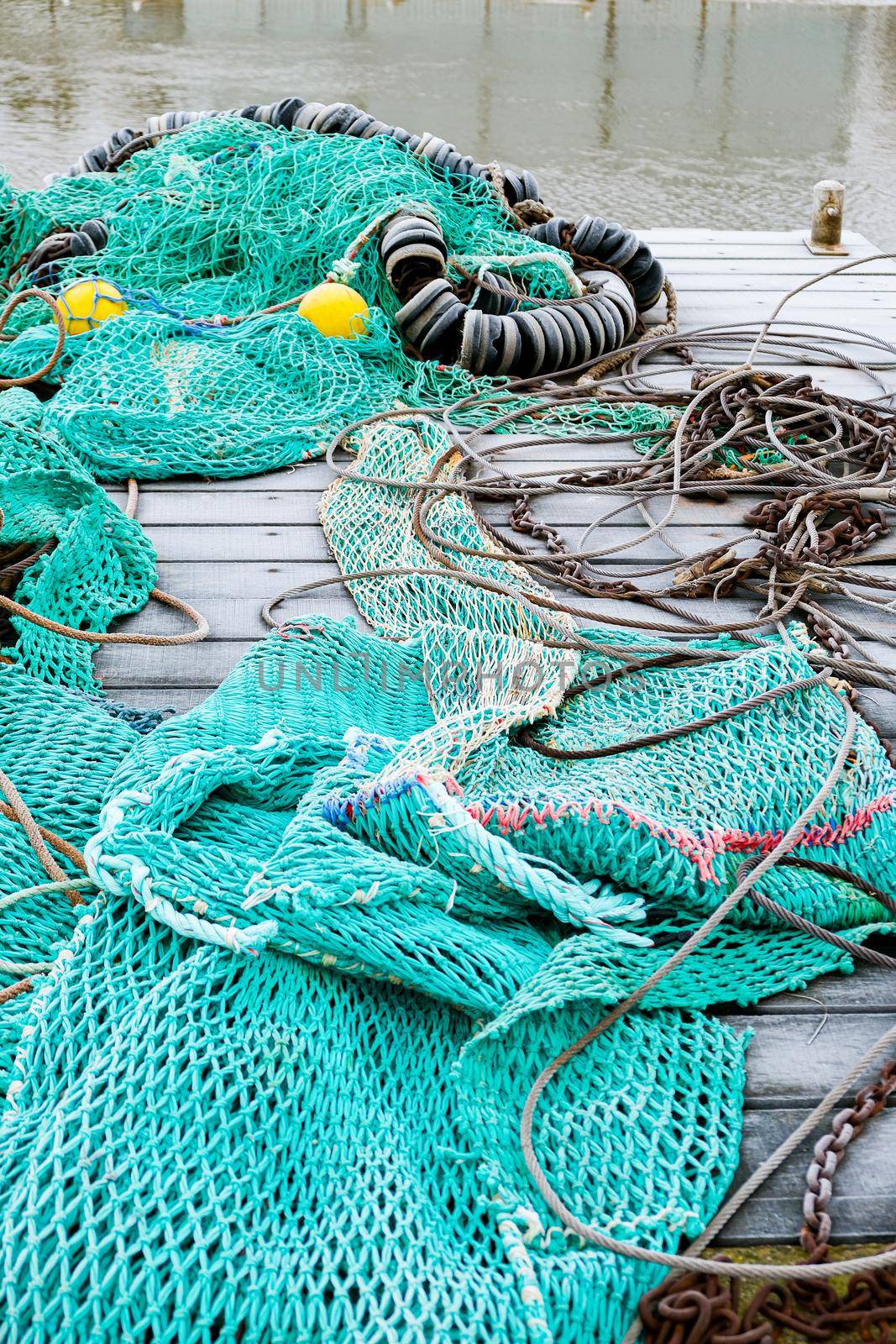 blue fishing net on a pontoon with its ropes and floats covered with morning frost