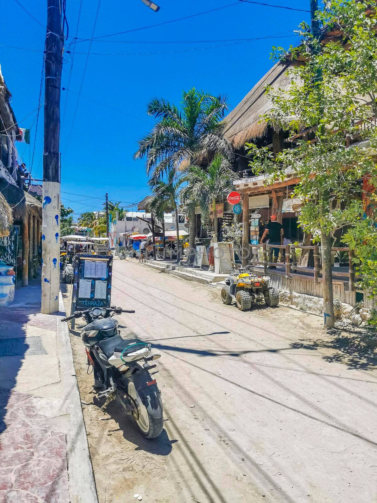 Holbox Mexico 16. May 2022 Colorful village on beautiful Holbox island with restaurant store vehicles people and mud in Quintana Roo Mexico.