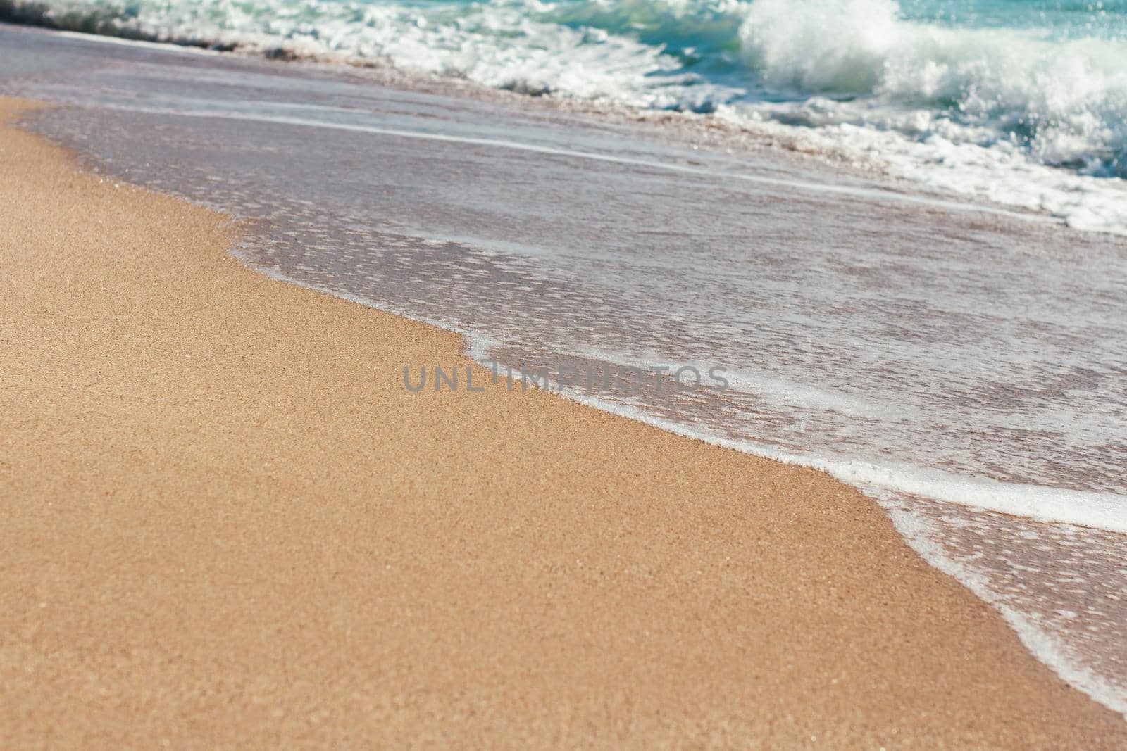 Deserted beach Sea waves overlook the sandy shore Summer background