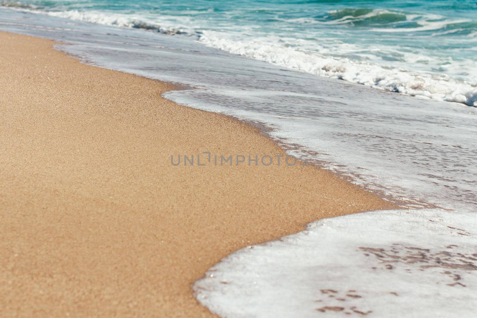 Deserted beach Sea waves overlook the sandy shore Summer background