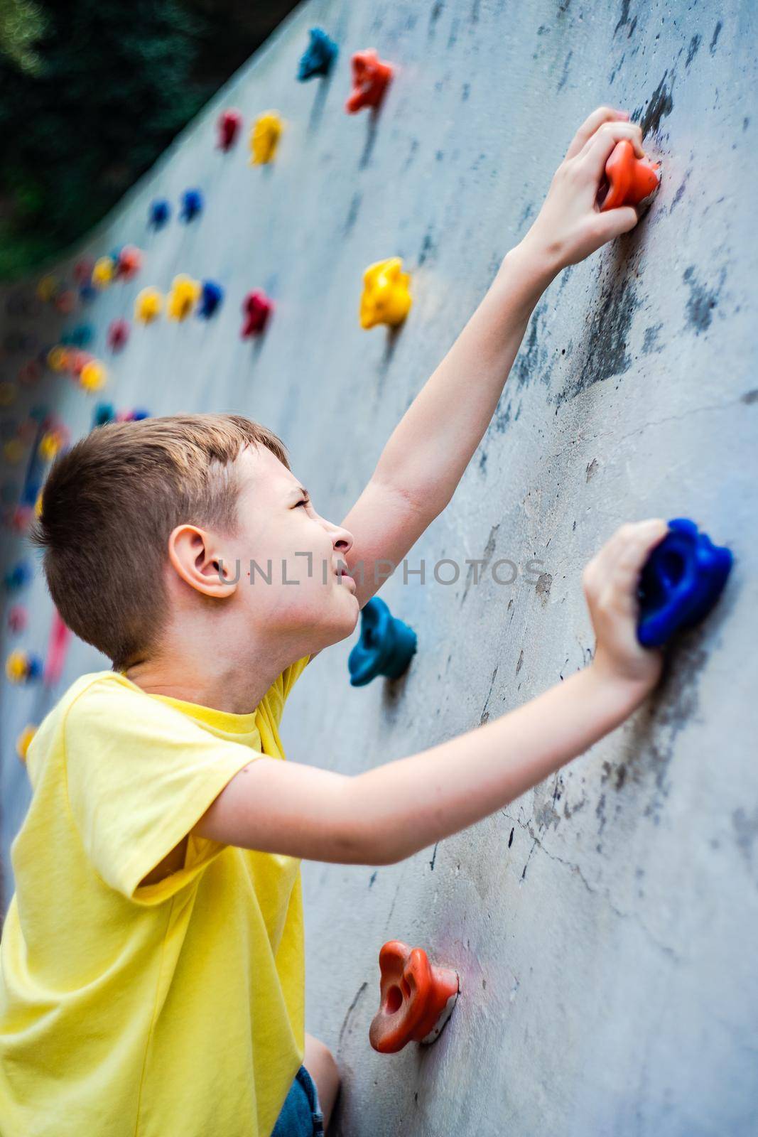 Boy playing on climbing wall by Elet