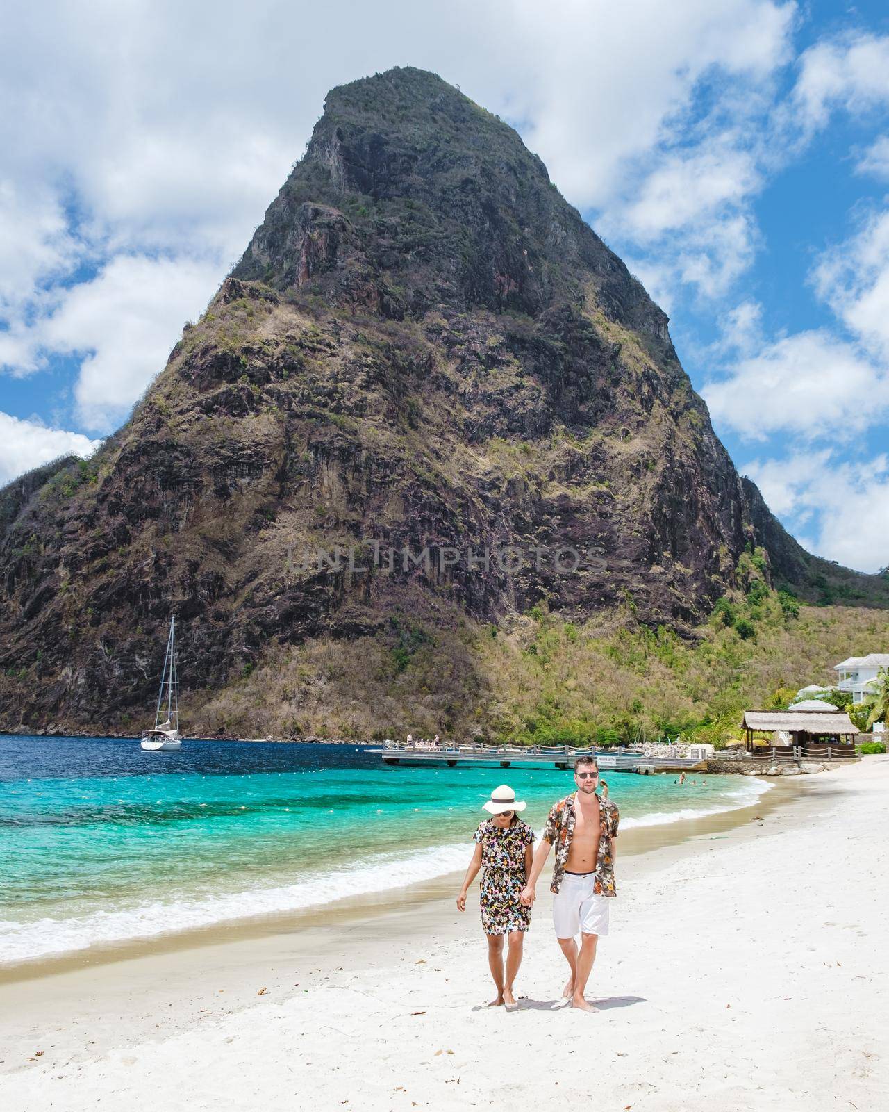 couple walking on the beach during summer vacation on a sunny day, men and woman on vacation at the tropical Island of Saint Lucia Caribbean. Sugar beach St Lucia Caribbean