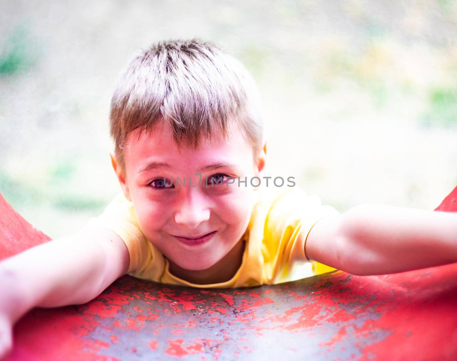 Beautiful boy playing outdoor in the summer park playground