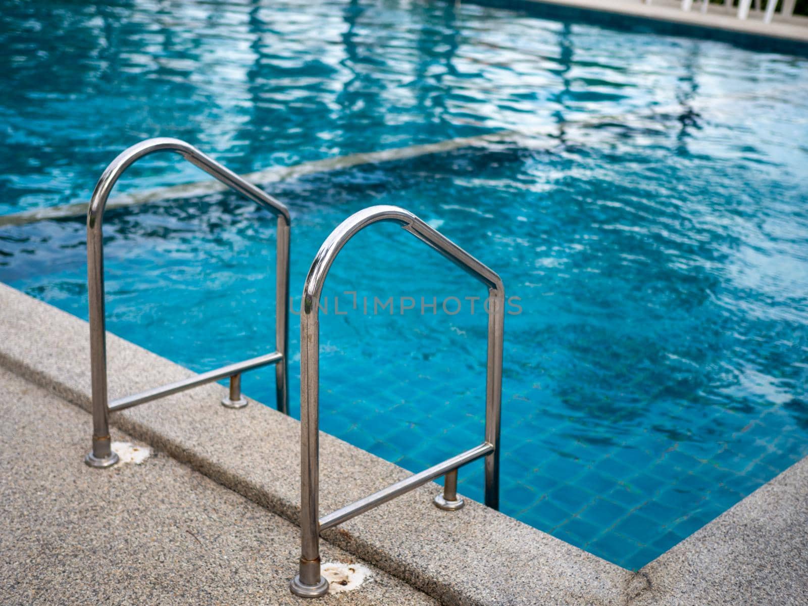 Stainless steel stairs to the pool. handrails up and down the pool.