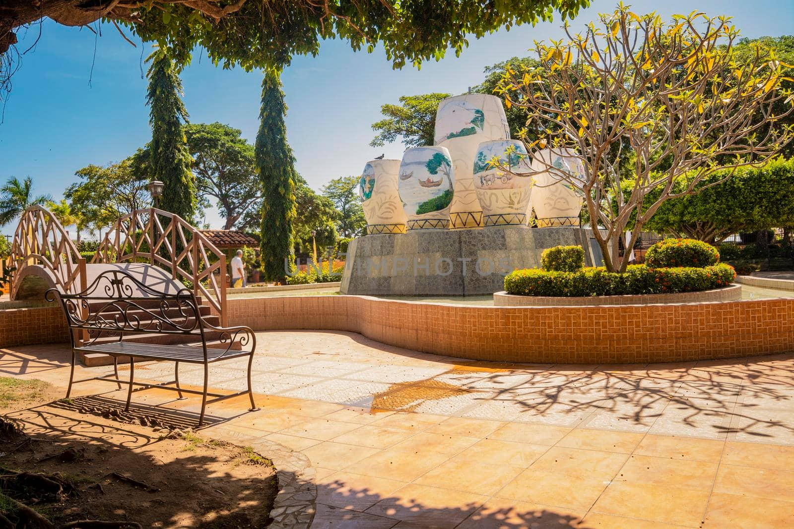 Traditional park of Nagarote, Nicaragua. A nice and relaxed park with a wooden bridge over a water fountain, View of a calm park with a small wooden bridge on a sunny day. Nagarote central park