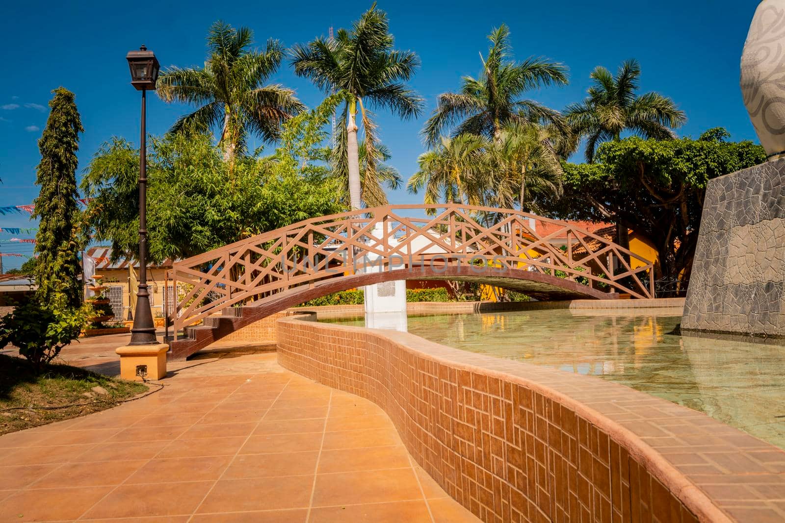 Nagarote central park.  View of a nice and relaxed park with a water fountain. Traditional, Side view of a small wooden bridge over a water fountain in a calm park. park of Nagarote, Nicaragua