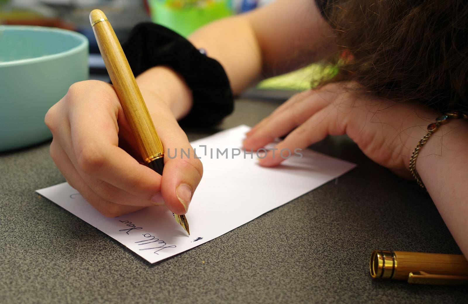 Hands of a young woman who's using a fountain pen