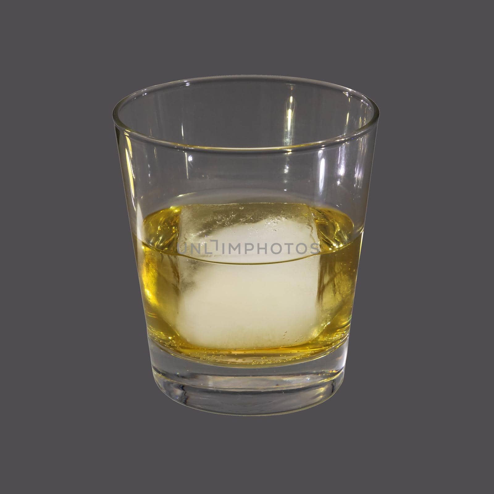 Studio photograph of a glass with an ice cube on grey background
