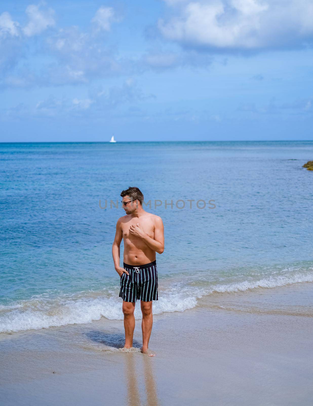 young men in a swim short on vacation in Saint Lucia, luxury holiday Saint Lucia Caribbean, men on vacation at the tropical Island of Saint Lucia Caribbean. Calabash beach St Lucia Caribbean