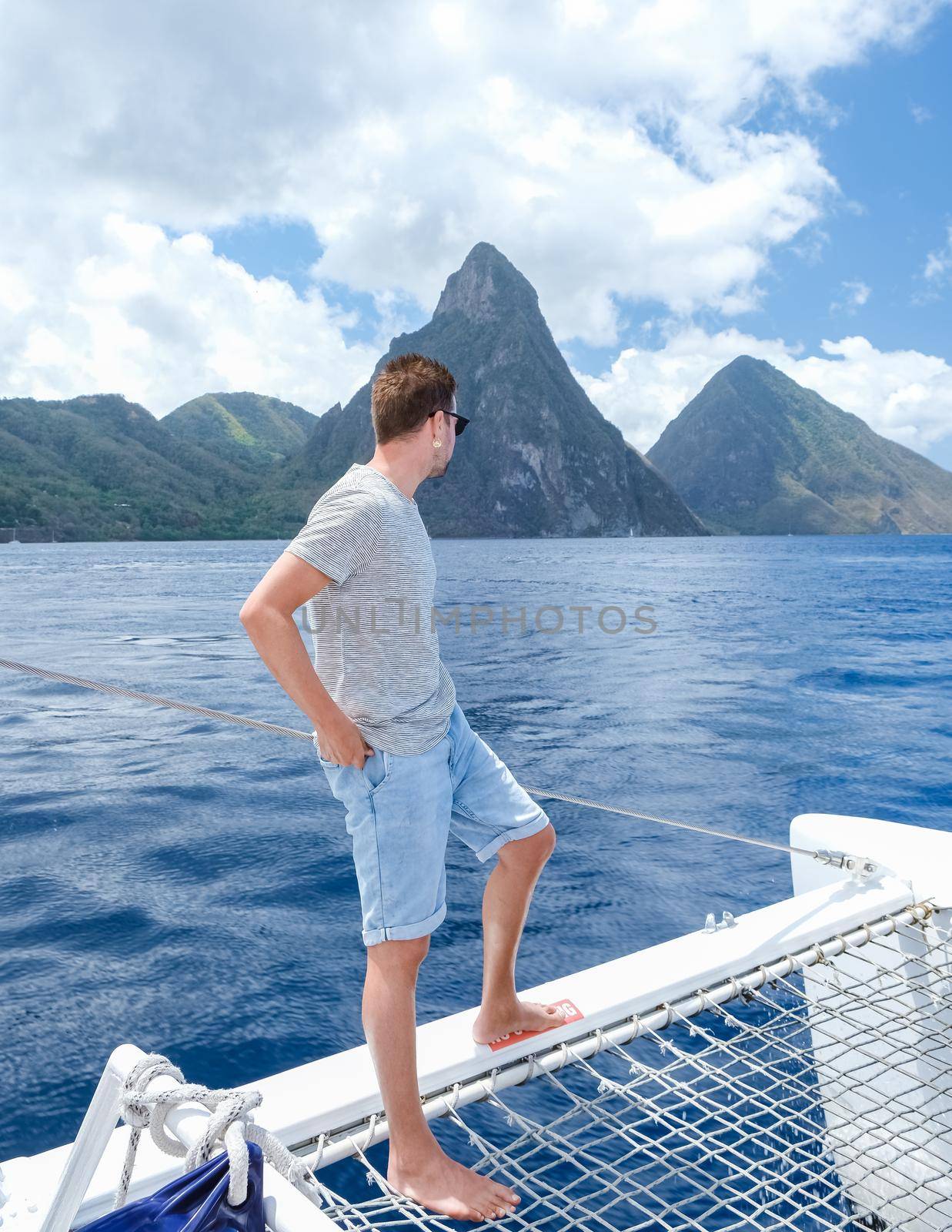 young men in swim short on a boat trip with a catamaran on vacation in Saint Lucia, luxury holiday Saint Lucia Caribbean, men on vacation at the tropical Island of Saint Lucia Caribbean.