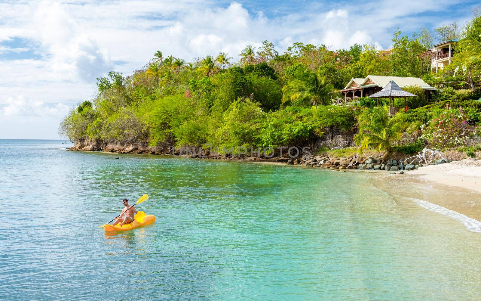 young men in a kayak at a tropical island in the Caribbean sea, St Lucia or Saint Lucia. young man on vacation on a tropical island