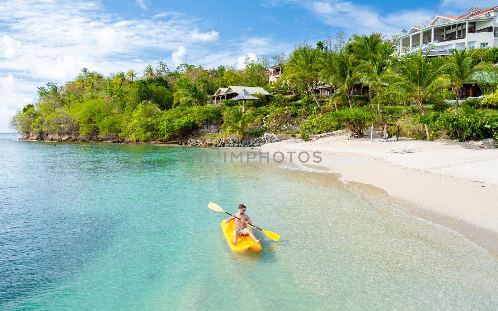 young men in a kayak at a tropical island in the Caribbean sea, St Lucia or Saint Lucia. young man on vacation on a tropical island