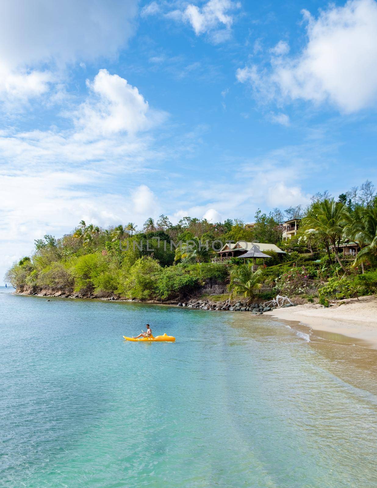 young men in a kayak at a tropical island in the Caribbean sea, St Lucia or Saint Lucia. young man on vacation on a tropical island