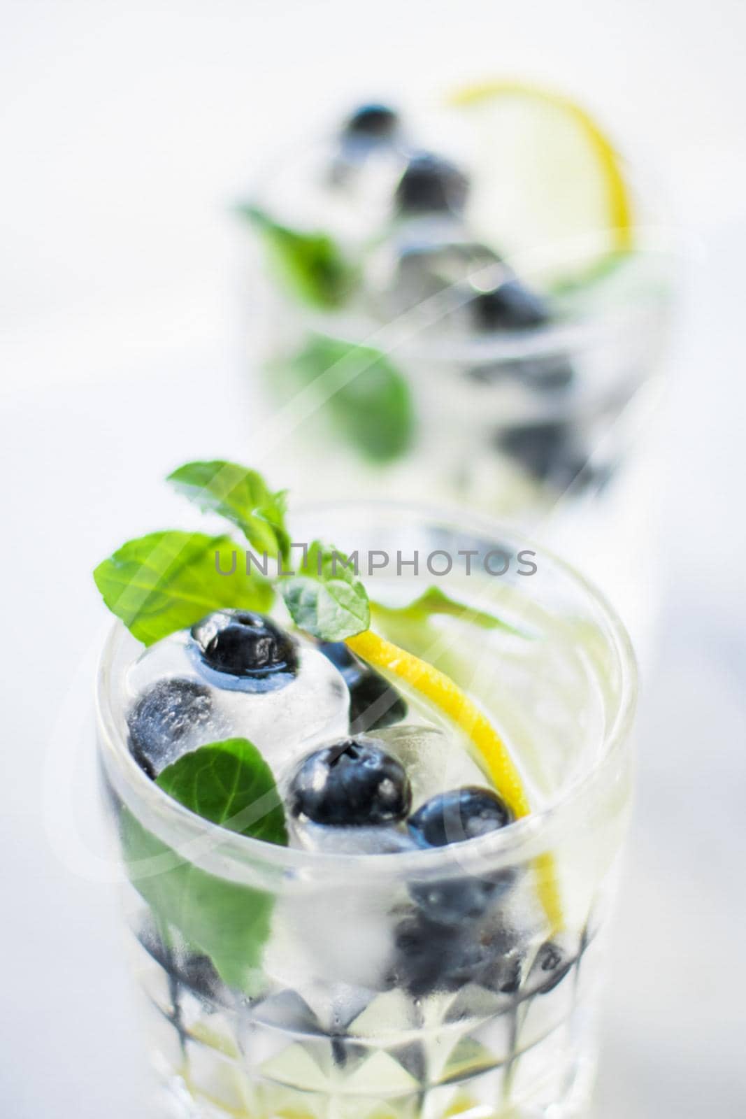 drinks, cocktails and celebration styled concept - cocktail with blueberry ice and lemon