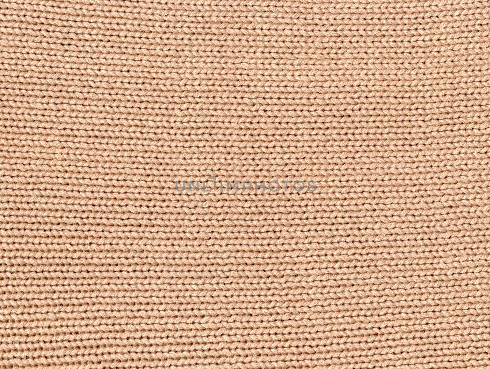 Beige knitted pattern background. Crochet fabric texture.