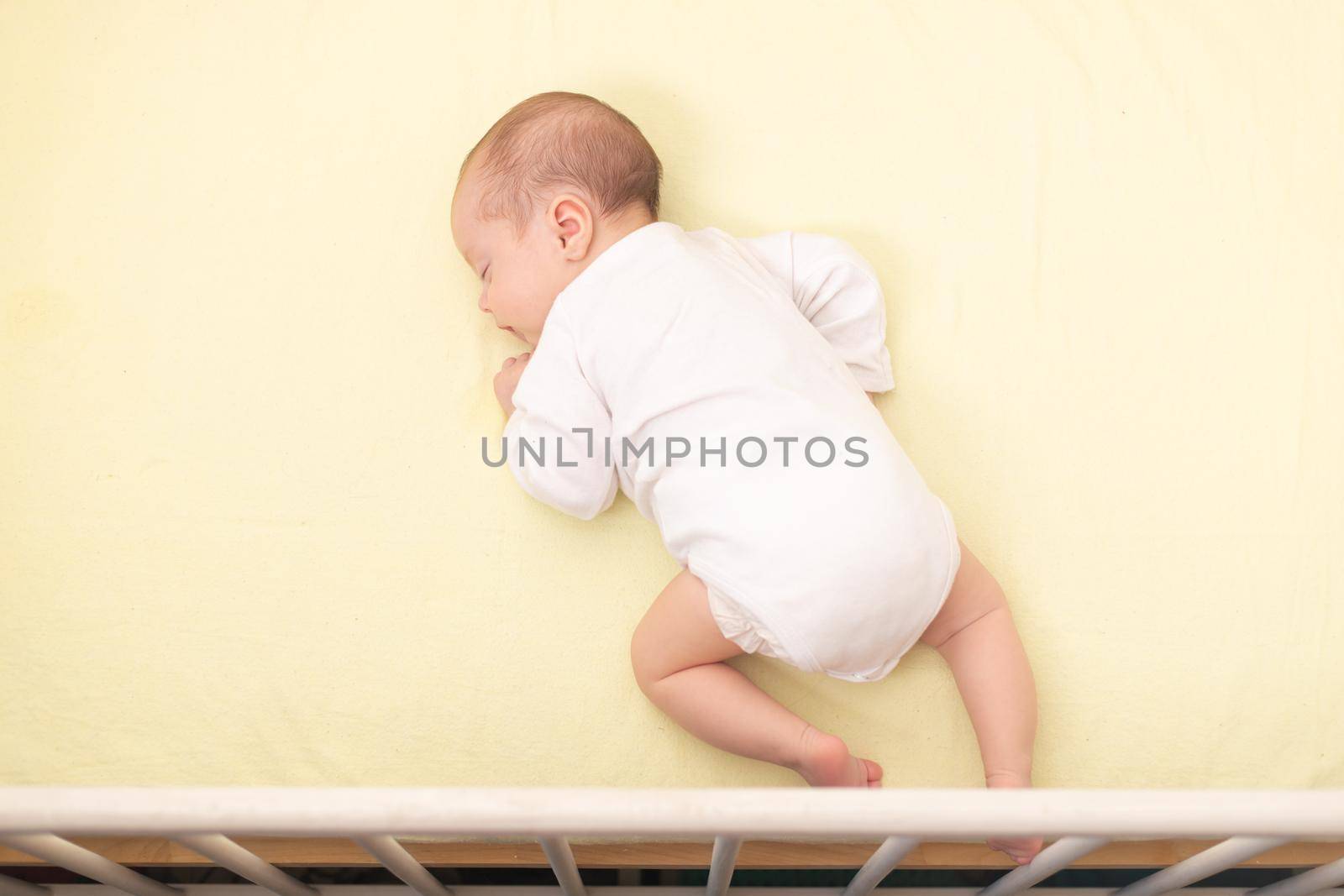 The baby sleeps in the copy space crib . Advertising of children's goods. Illustrating children's articles. A small child. A newborn. A child's dream.