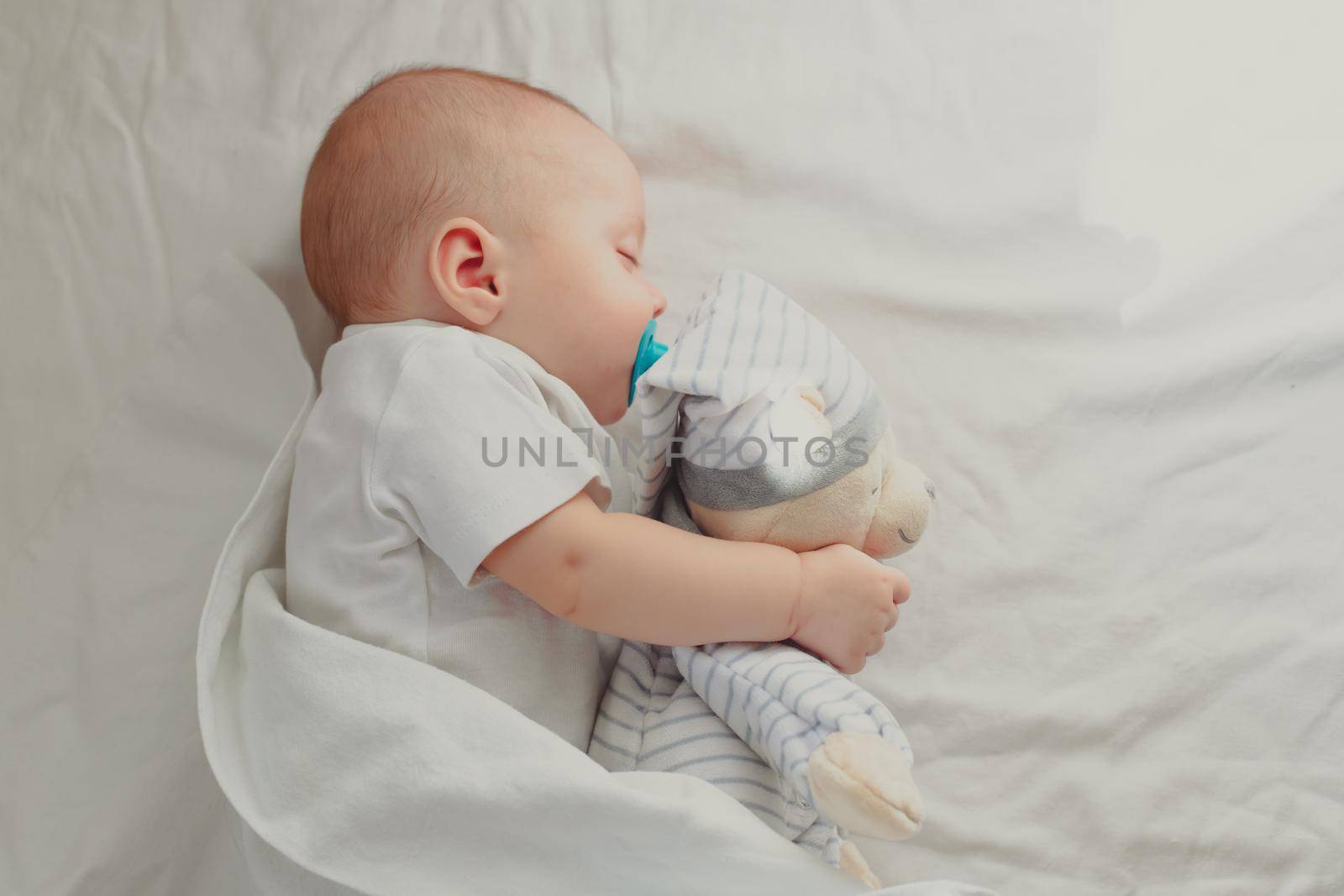 The baby is sleeping in his crib. Happy baby dream. A happy child. Children's article. Copy Space