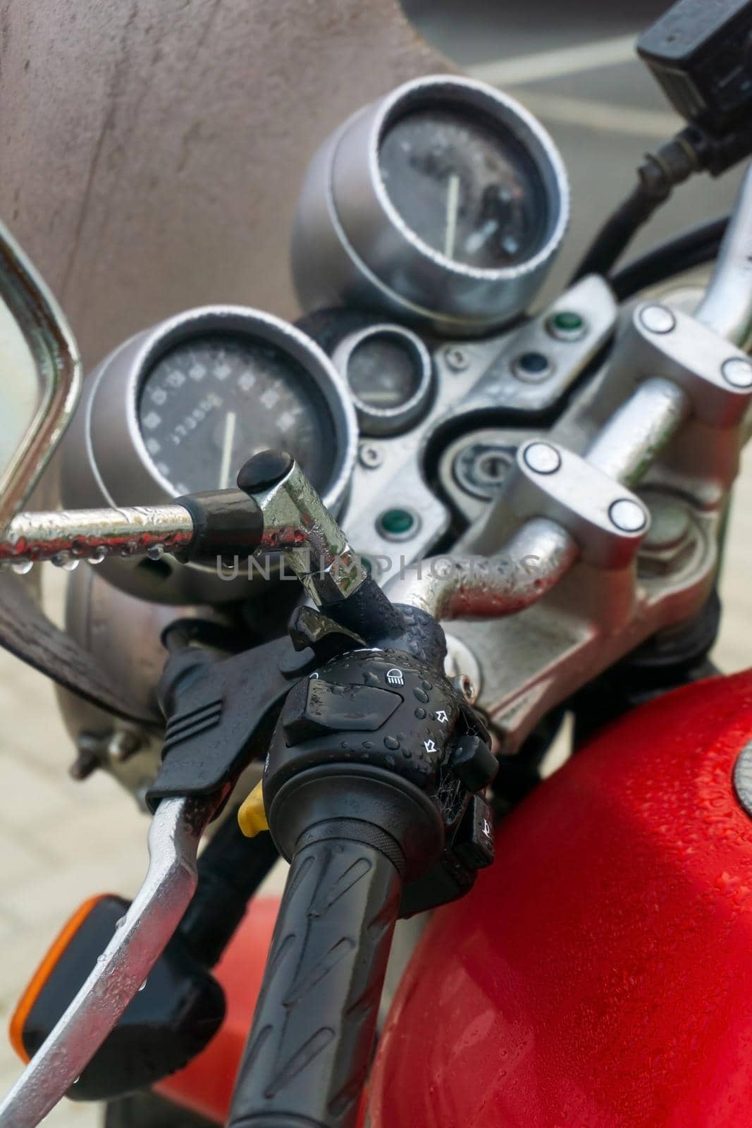 Steering wheel and dashboard of a red classic motorcycle close up