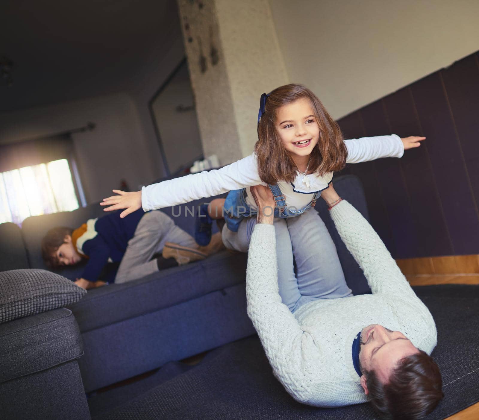 Take me higher. a man lifting his daughter into mid-air