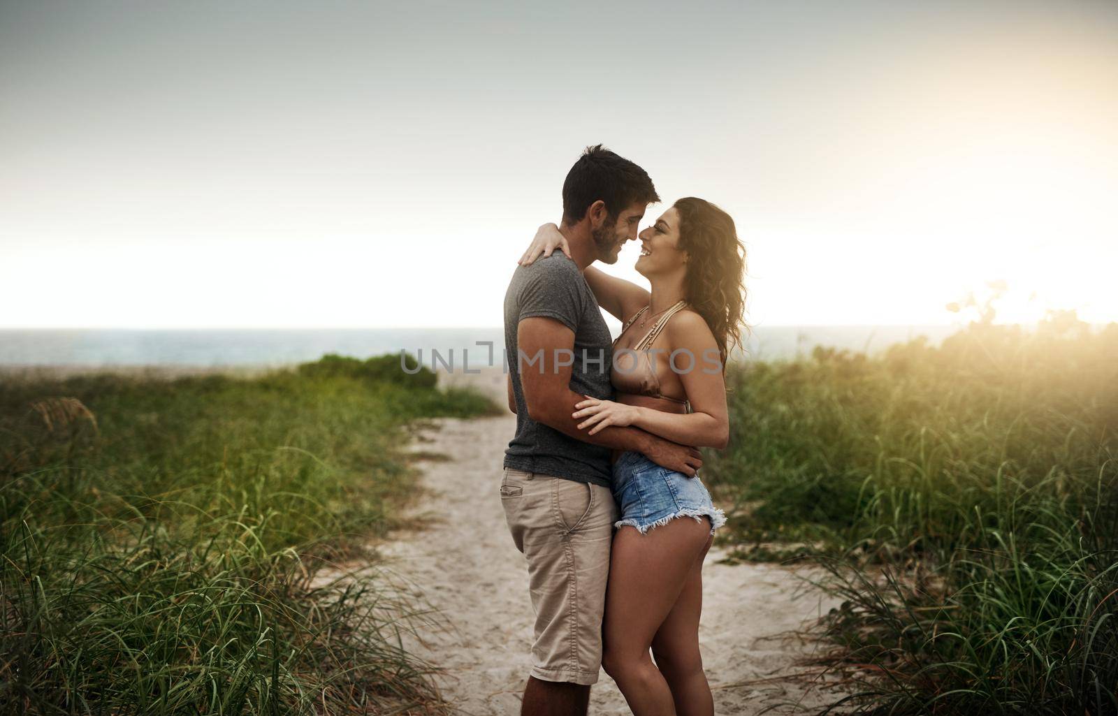 Nothing says summer romance like a day at the beach. a young couple spending a romantic day at the beach. by YuriArcurs