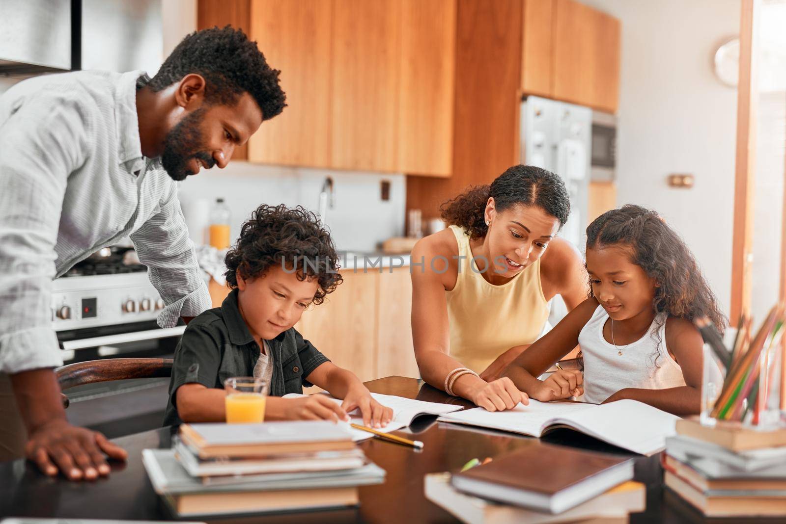 Play an active role in your childs homework. parents helping their two children with their homework. by YuriArcurs