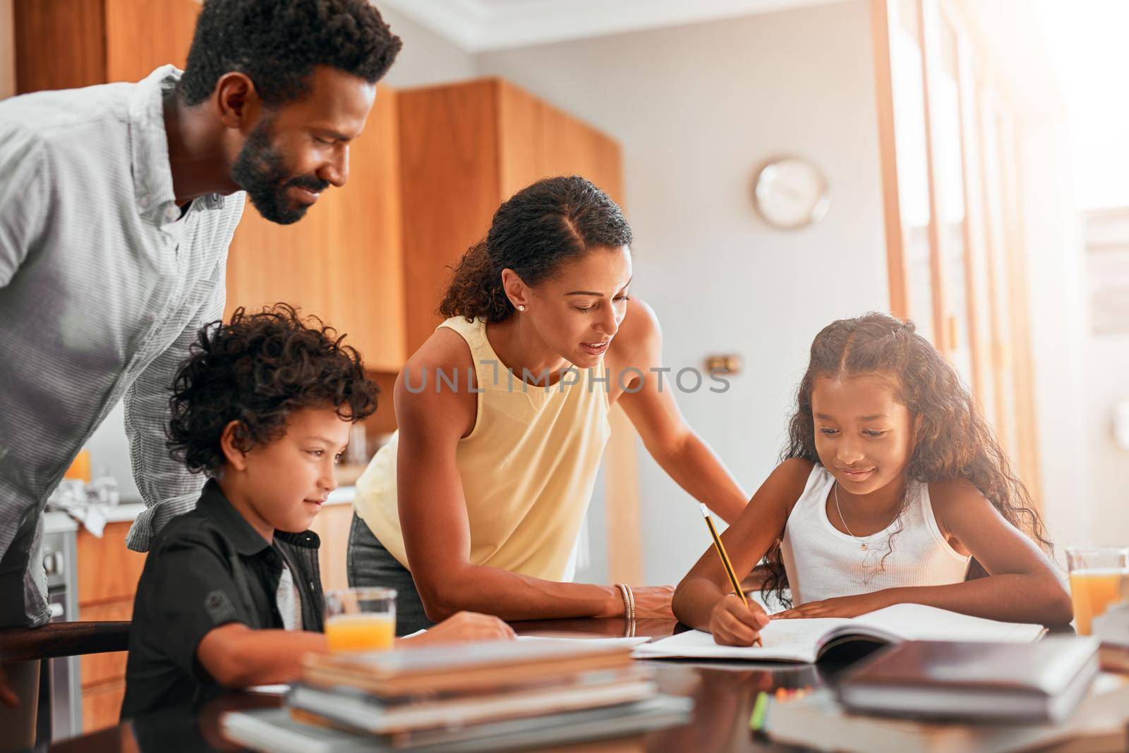 Getting homework done before playtime. parents helping their two children with their homework