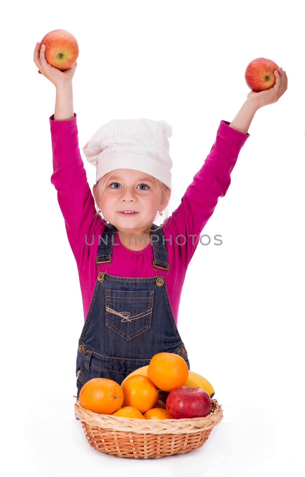 Close-up portrait of a little girl holding fruits - apples, bananas and oranges. Isolated on a light background. by aprilphoto