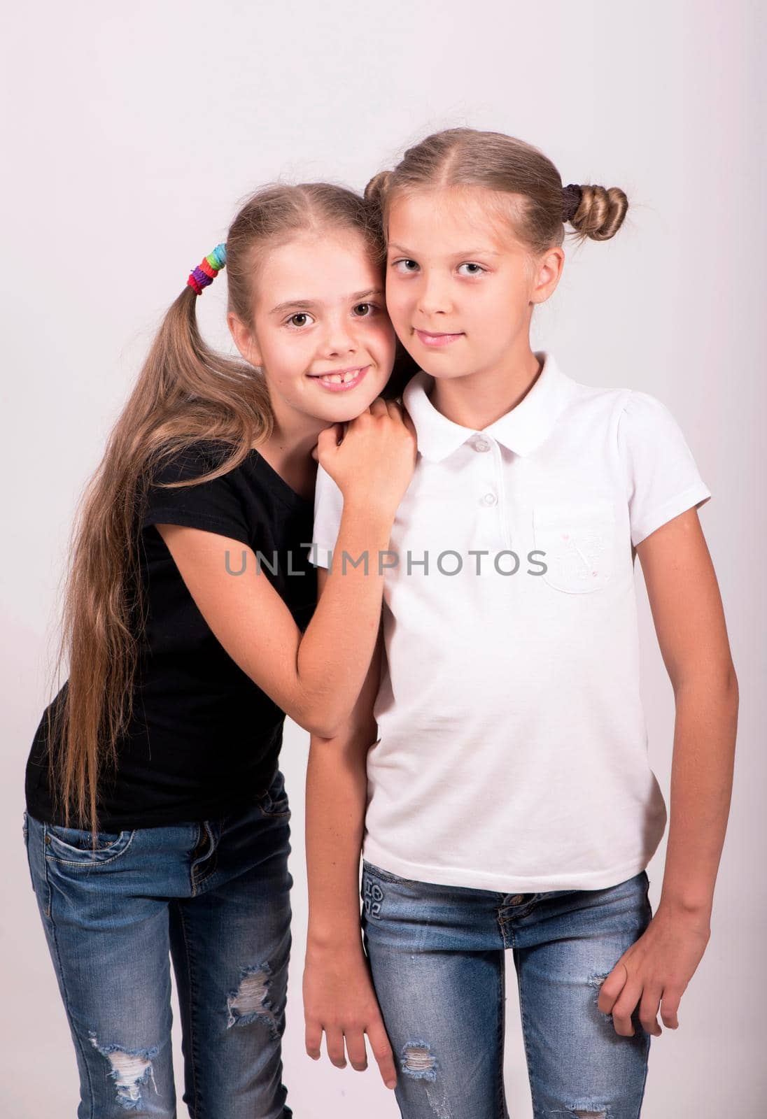 two girlfriends. Cute happy girls in black and white t-shirt on a white background. by aprilphoto
