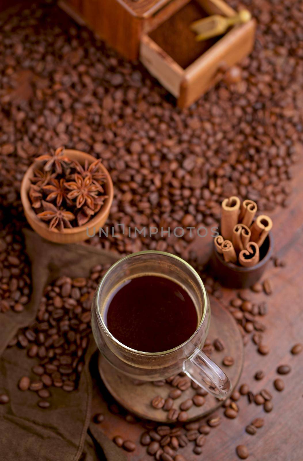 Hot black coffee and coffee beans on the old wooden table