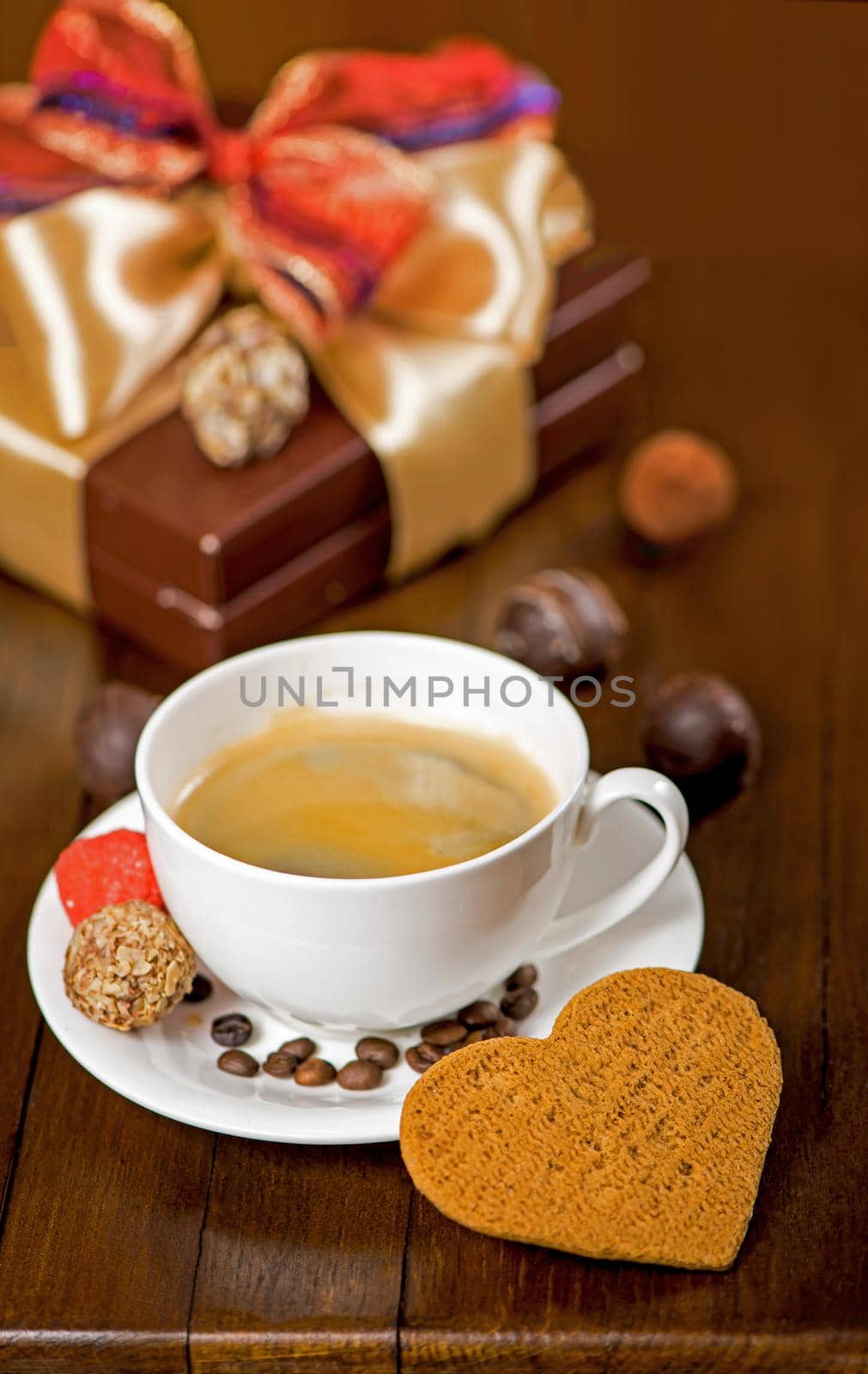 a cup of coffee and candy on vintage wooden background