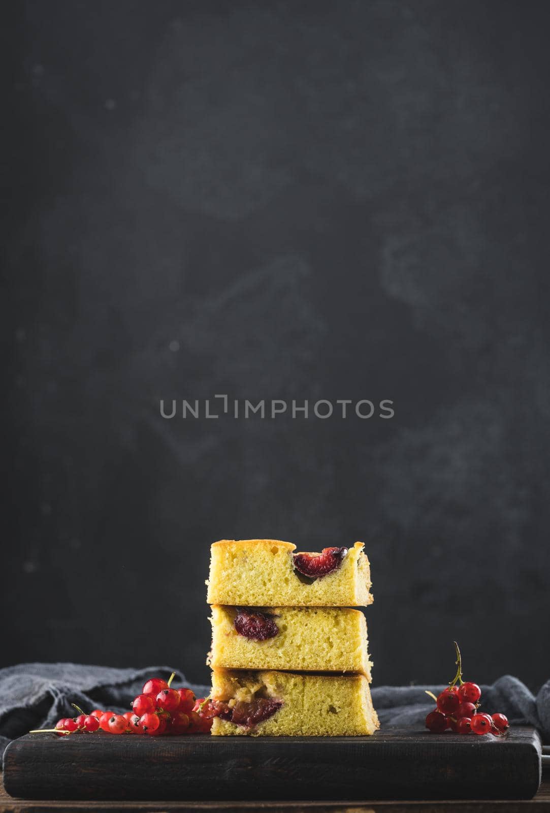 Stack of square slices of baked plum biscuit cake, copy space